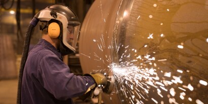 Man weld grinding on tank with grinder and 3M Silver abrasive wheel
