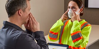 worker donning a disposable respirator with Wear it Right app
