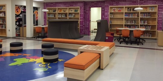 A library has a large floor graphic film of the globe.
