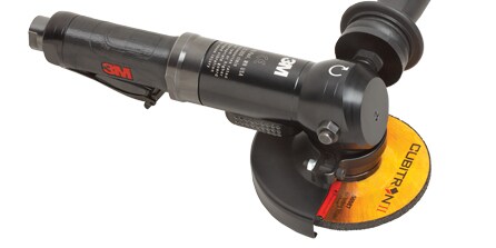 A black circular grinder with a black handle
