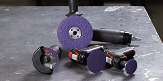 3M abrasive discs and power tools arranged on a metal workbench for collision repair applications
