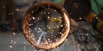 Grinder using 3M Silver wheel to cut metal pipe with sparks flying
