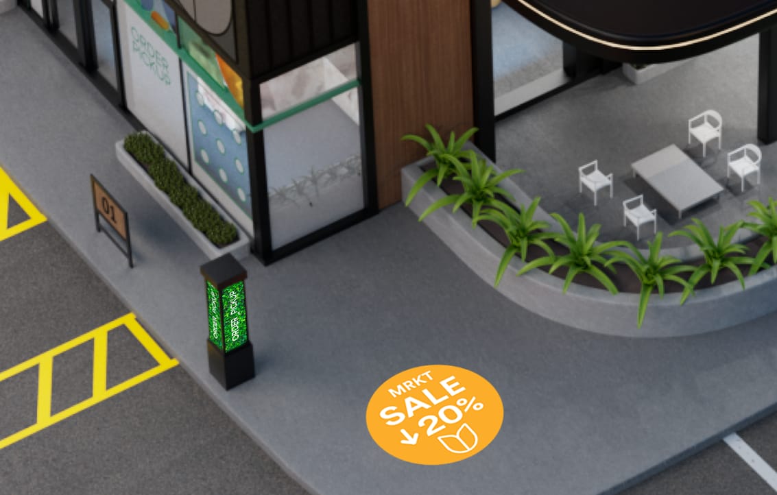 Storefront with illuminated signs and parking area, showcasing a green wall and delivery vans. 
