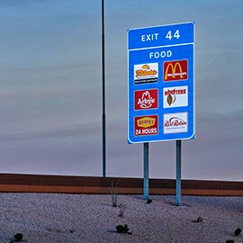 reflective signage on the side of a highway displaying local food resources