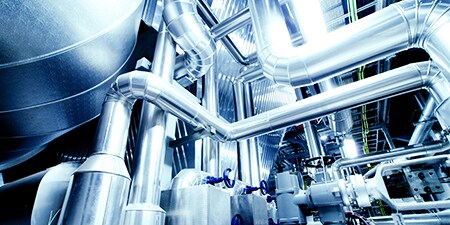 Long and complicated industrial metallic pipes running into one another.
