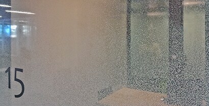 A one-way mirror created by 3MTM Glass Finishes lets viewers peer into a small conference room.
