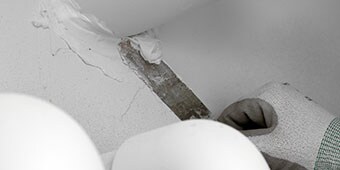 Worker sealing a joint around a pipe
