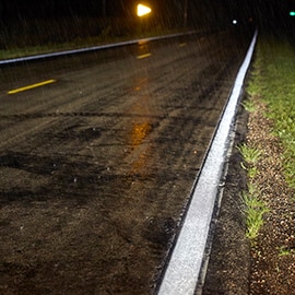 Reflective road markings under wet pavement and inclement weather conditions.