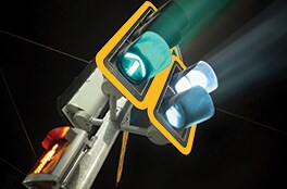A large traffic signal with reflective backplates shines brightly at nighttime.